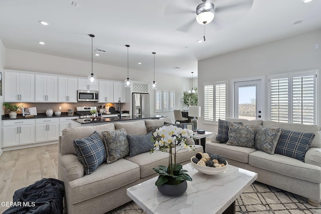 living area featuring ceiling fan, light wood-style flooring, and recessed lighting