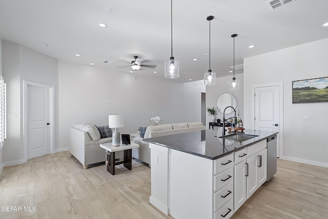 kitchen with dishwasher, a sink, visible vents, and light wood-style floors