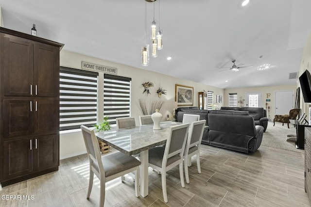 dining space with visible vents, a ceiling fan, and vaulted ceiling