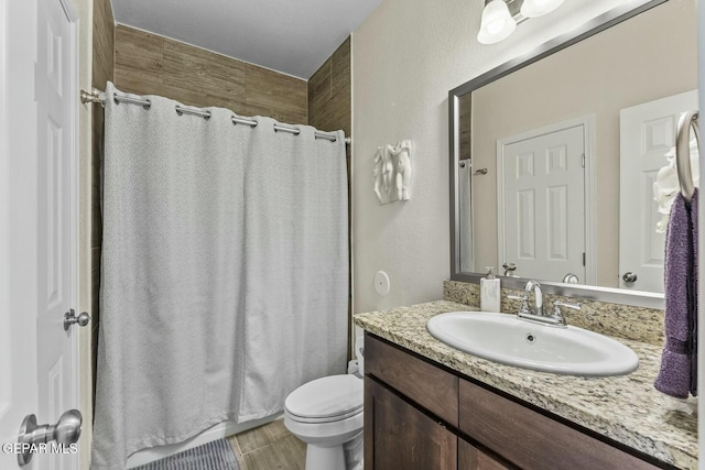 bathroom with toilet, vanity, and a shower with shower curtain