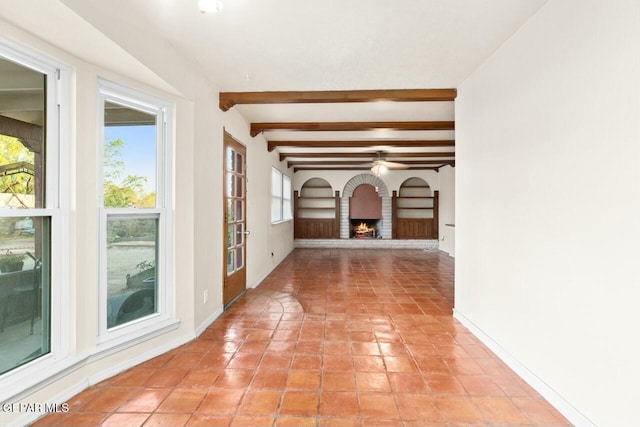 hallway featuring beamed ceiling, light tile patterned flooring, and baseboards