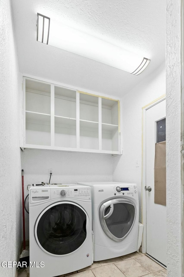 clothes washing area with a textured ceiling, laundry area, and washer and dryer