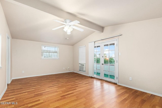 empty room with light wood-type flooring, vaulted ceiling with beams, a wealth of natural light, and french doors