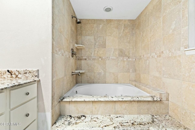 bathroom with tiled shower / bath combo and vanity