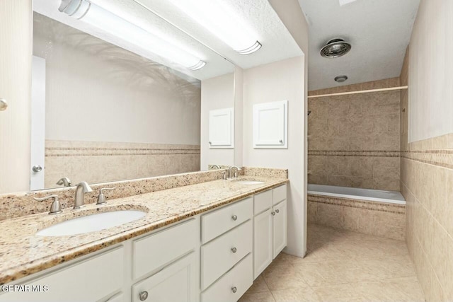 full bathroom featuring double vanity, a sink, tiled shower / bath, and tile patterned floors