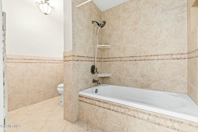 bathroom featuring tiled shower / bath combo, tile walls, toilet, and tile patterned floors