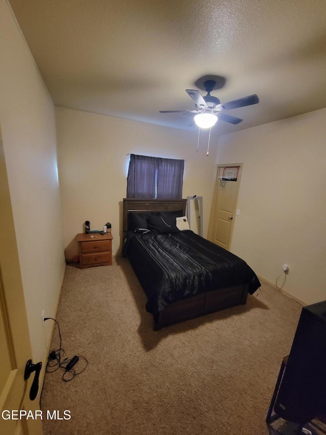 bedroom featuring a ceiling fan, carpet, and a textured ceiling