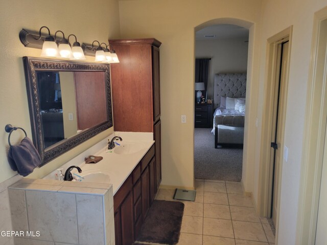 bathroom featuring tile patterned flooring, ensuite bath, and a sink