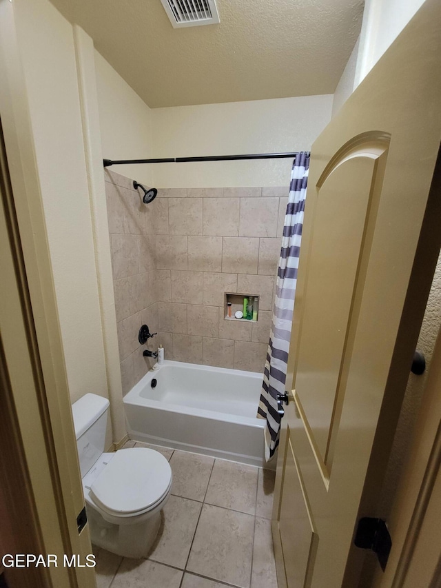 bathroom featuring shower / tub combo, visible vents, toilet, tile patterned flooring, and a textured ceiling