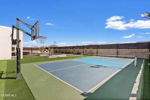 view of basketball court with a tennis court and fence