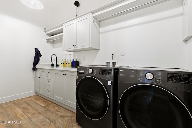 laundry room with light wood-style flooring, cabinet space, independent washer and dryer, and baseboards