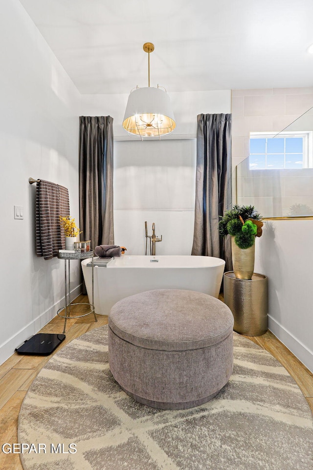 bathroom featuring baseboards and a freestanding bath