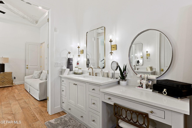 bathroom with vanity, baseboards, and wood finished floors