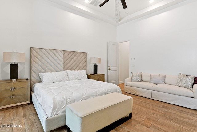 bedroom featuring a ceiling fan, visible vents, a high ceiling, recessed lighting, and wood-type flooring