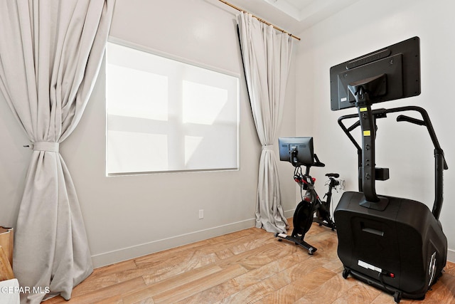 exercise area with baseboards and wood finished floors