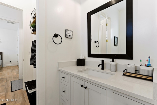 bathroom featuring visible vents, wood finished floors, and vanity