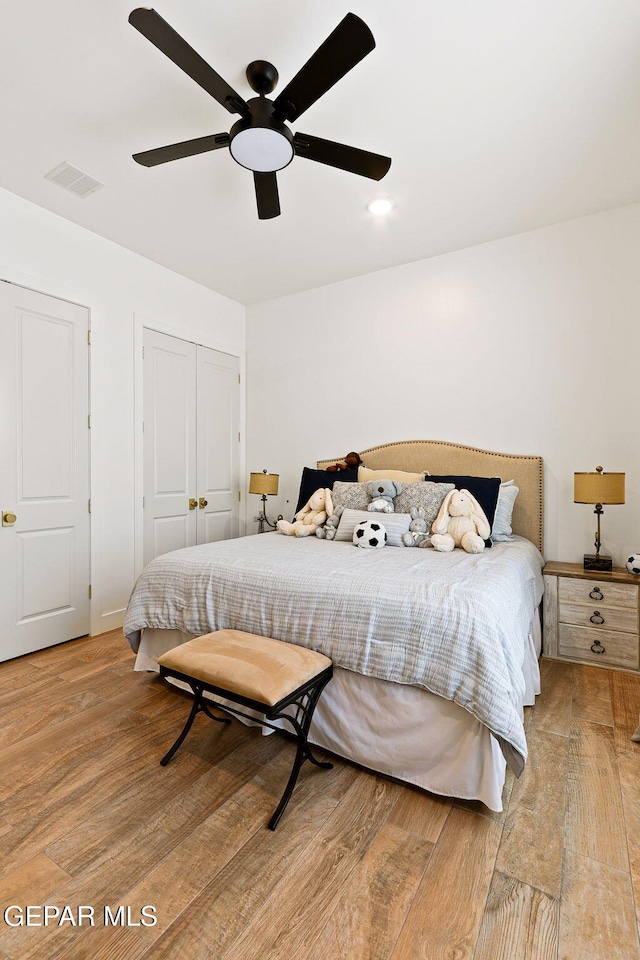 bedroom featuring a ceiling fan, visible vents, a closet, and light wood-type flooring