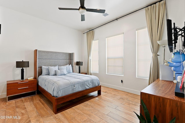 bedroom featuring visible vents, baseboards, light wood-style flooring, and a ceiling fan