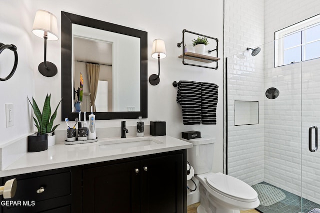 bathroom with vanity, a shower stall, and toilet