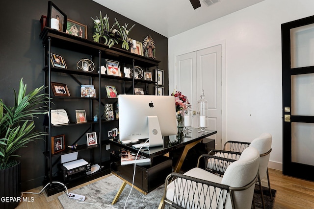 home office featuring wood finished floors, visible vents, and baseboards