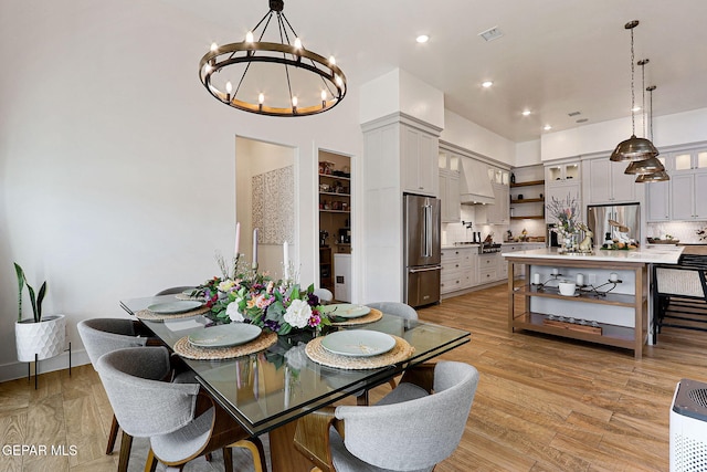 dining area with a notable chandelier, visible vents, light wood-style flooring, and recessed lighting