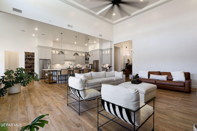 living area with visible vents and wood finished floors