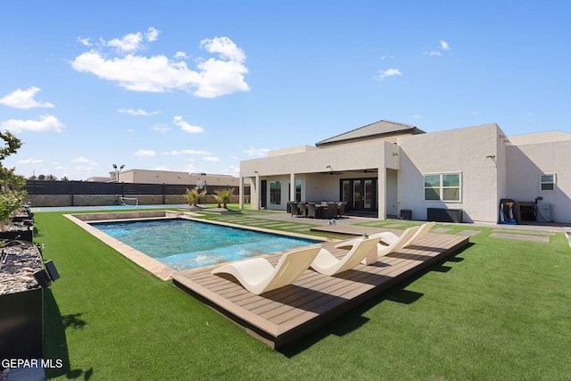 view of swimming pool with a fenced in pool, fence, ceiling fan, french doors, and a lawn