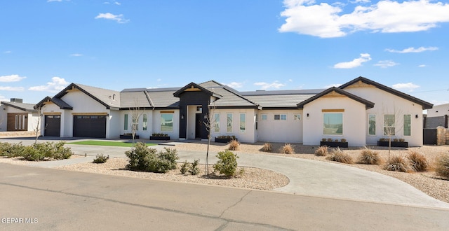 view of front of property featuring solar panels, a tile roof, concrete driveway, stucco siding, and a garage