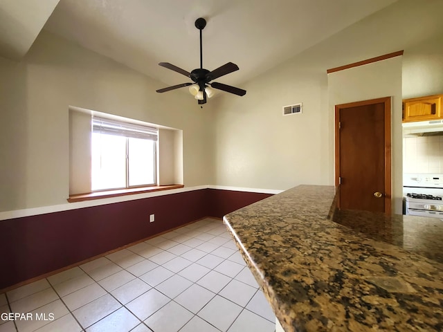 interior space with light tile patterned floors, visible vents, ceiling fan, and vaulted ceiling