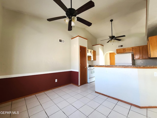 kitchen featuring visible vents, white appliances, lofted ceiling, and a peninsula