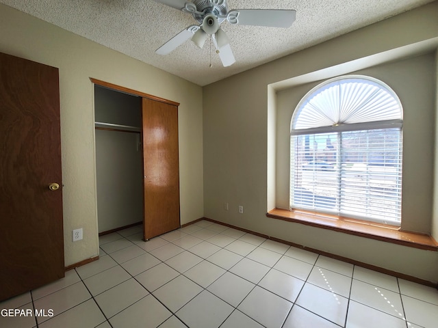 unfurnished bedroom featuring baseboards, a ceiling fan, a closet, and a textured ceiling