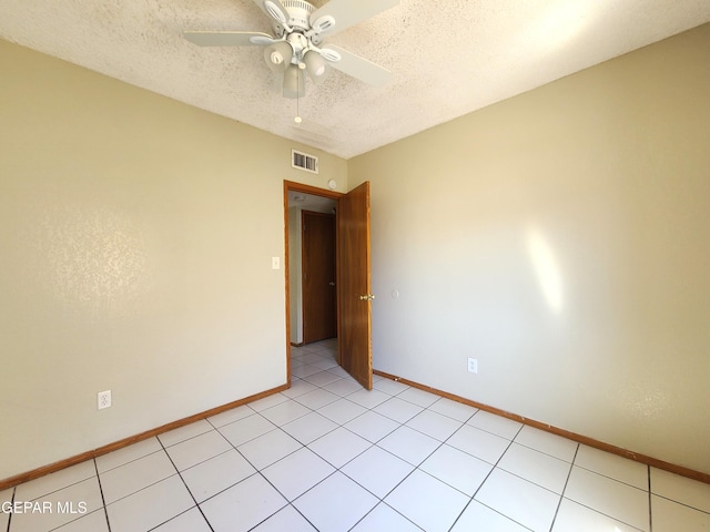 empty room featuring visible vents, baseboards, a textured ceiling, and ceiling fan