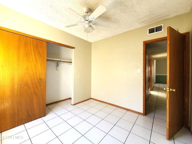 unfurnished bedroom with visible vents, a textured ceiling, a closet, baseboards, and ceiling fan