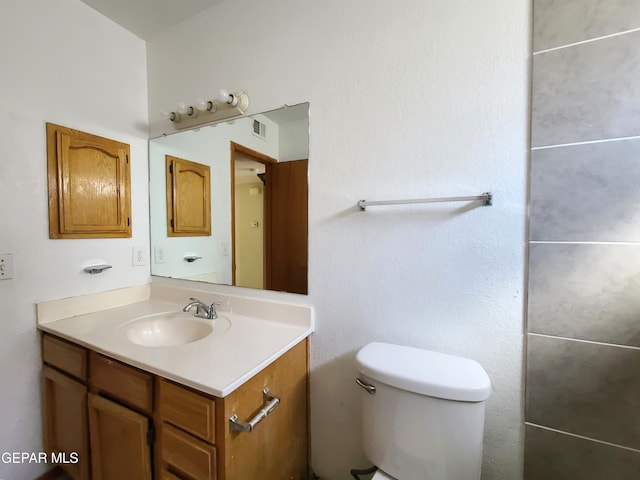 bathroom featuring vanity, toilet, and visible vents