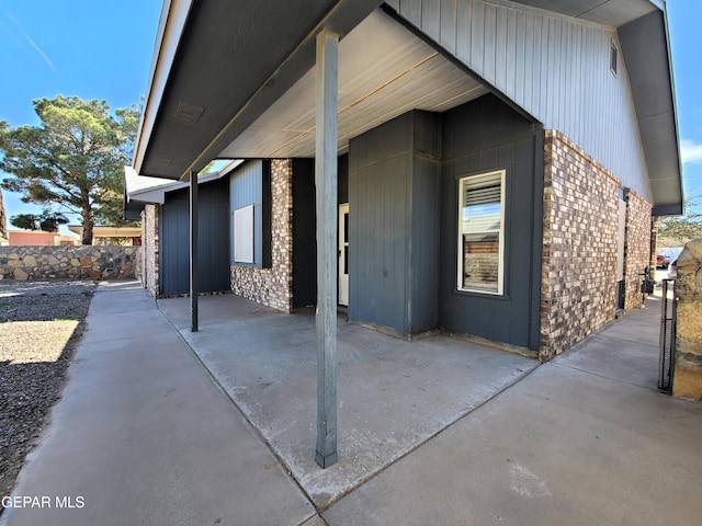 exterior space with a patio area and brick siding