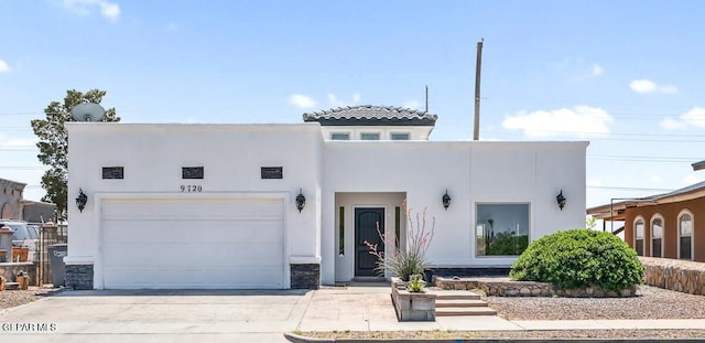 view of front of house with a garage, concrete driveway, and stucco siding