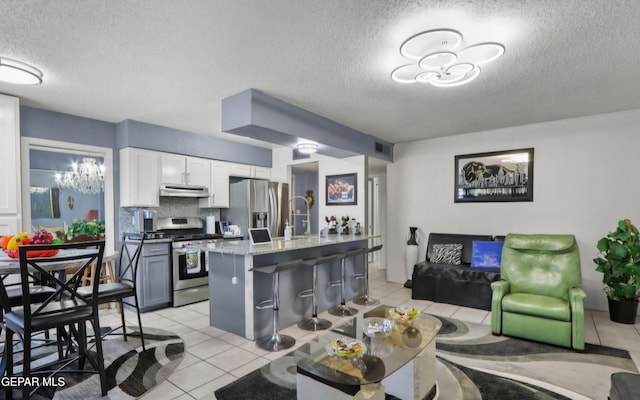 living area with an inviting chandelier, visible vents, a textured ceiling, and light tile patterned flooring