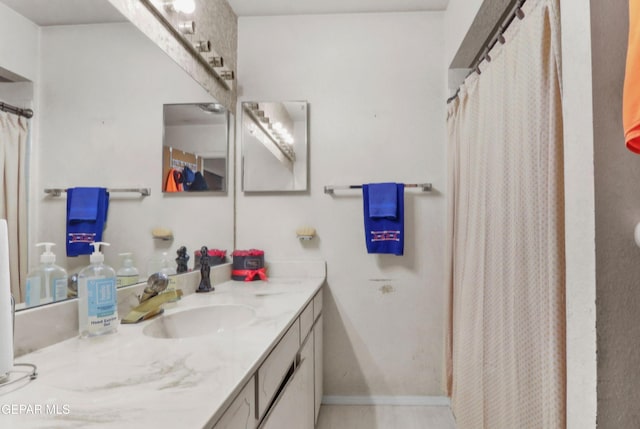 bathroom featuring a shower with shower curtain, vanity, and baseboards