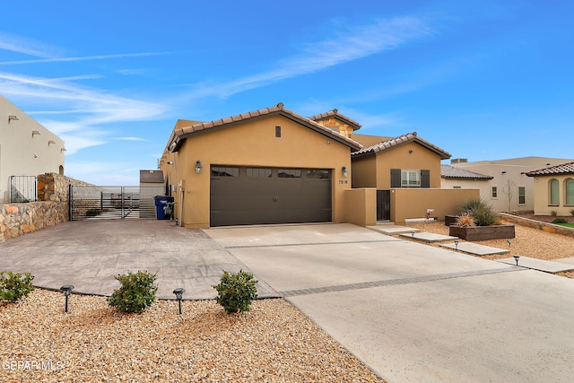 view of front of home with fence, concrete driveway, stucco siding, a garage, and a gate