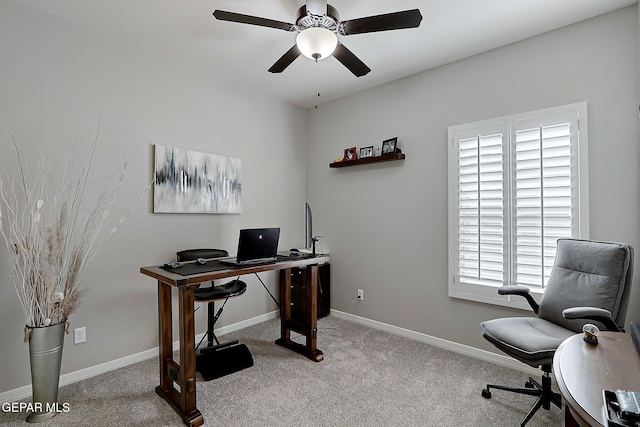 carpeted office featuring baseboards and a ceiling fan