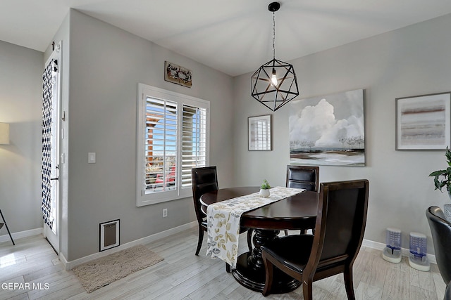 dining area with light wood-style flooring and baseboards