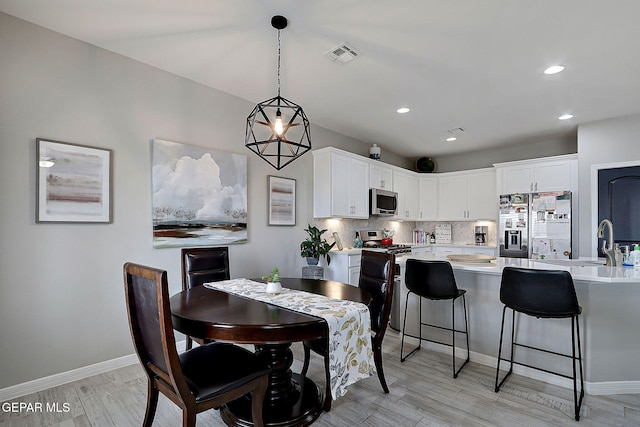 dining room featuring recessed lighting, baseboards, visible vents, and light wood finished floors