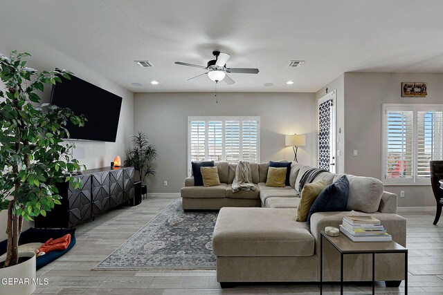 living room with light wood-style floors, a healthy amount of sunlight, and visible vents