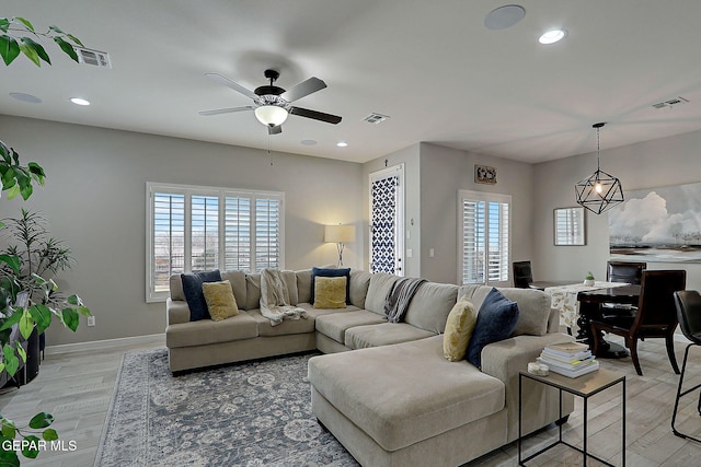 living area featuring plenty of natural light, light wood-style floors, and visible vents