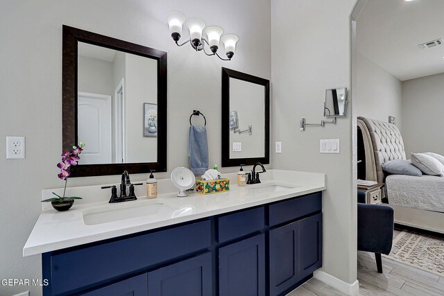 bathroom with double vanity, wood finished floors, visible vents, and a sink