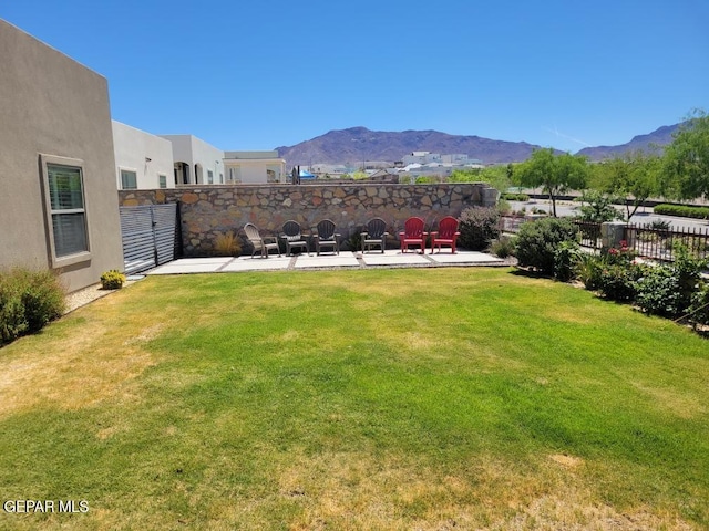 view of yard with a patio, fence, and a mountain view