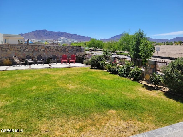 view of yard featuring a patio, fence, and a mountain view