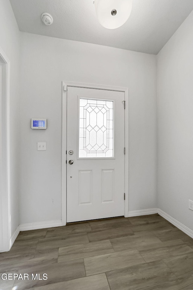 foyer featuring baseboards and wood finished floors