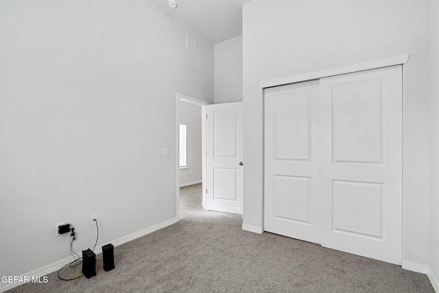 unfurnished bedroom featuring carpet flooring, baseboards, visible vents, and a closet