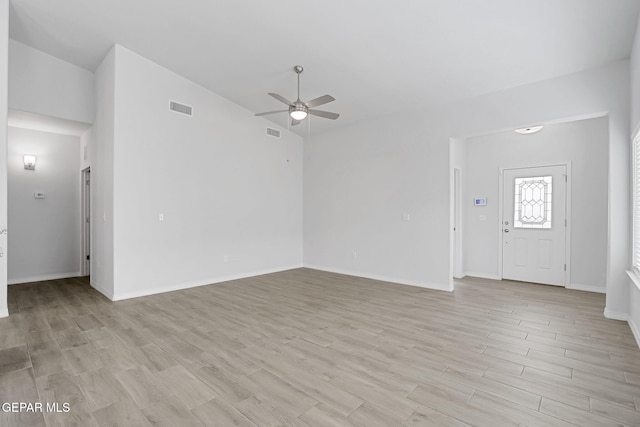 unfurnished living room with light wood-type flooring, visible vents, baseboards, and a ceiling fan